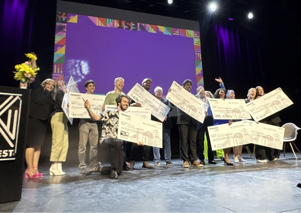 A group of people on a stage holding signsAI-generated content may be incorrect.